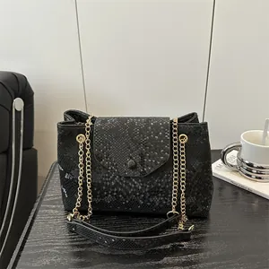 Chic black snakeskin texture shoulder bag with gold chain strap and stylish flap closure
