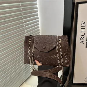 Large dark brown faux snakeskin shoulder bag with gold chain strap for women