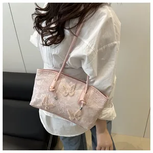 Detail of pink lace tote bag featuring 3D butterfly embroidery shown on a model