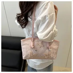 Detail of pink lace tote bag with 3D butterfly embroidery and leather knot straps
