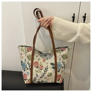 Detail of floral jacquard tote bag with vintage flower patterns and brown leather handles