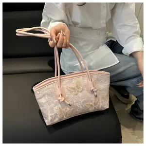 Detail of pink lace tote bag featuring 3D butterfly appliqués and thin leather straps
