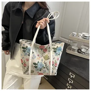 Detail of floral woven tote bag featuring colorful embroidery and durable handles