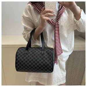 Détail d'un sac Boston vintage avec motif monogramme M et poignées en cuir noir