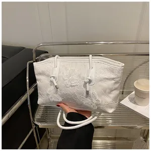 Detailed close-up of white lace tote bag with elegant 3D butterfly embroidery pattern