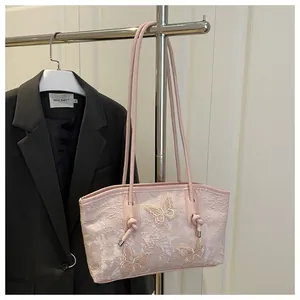 Detail of light pink tote bag featuring lace texture and 3D butterfly embroidery