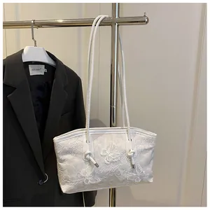 Close-up of white tote bag featuring intricate 3D butterfly lace embroidery and texture