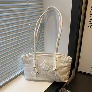 White floral lace tote bag with 3D butterfly embroidery shown in elegant window light