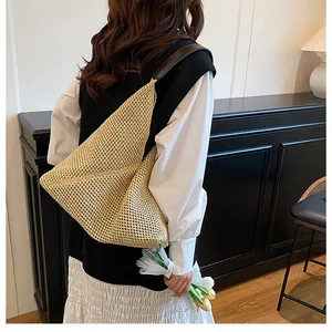 Detail of a beige woven tote bag with brown leather straps shown in a retro interior setting
