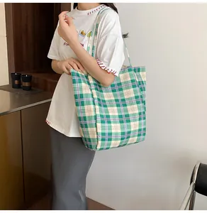Gros plan du sac cabas en toile à carreaux verts avec bandoulière en nylon