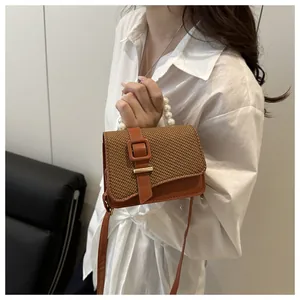 Detail of caramel PU leather and woven fabric mini square bag with pearl handle