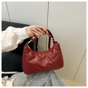 Dettaglio borsa hobo rosso scuro con trama saia e finiture in metallo dorato