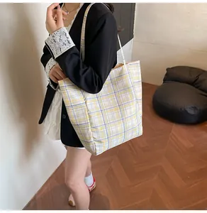 Vue détaillée du sac cabas à carreaux jaunes et bleus porté à l'épaule par un mannequin