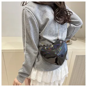 Fashionable heart-shaped holographic black patent leather bag with silver chain strap worn by model