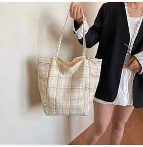 Checkered tote bag in yellow and purple held by a model for a chic daily commute style