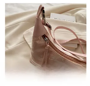 Close-up of smooth silver zipper and pink floral lace fabric with butterfly charms