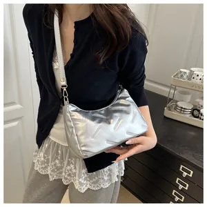 Borsa sottobraccio metallizzata argento con trama geometrica indossata da una modella