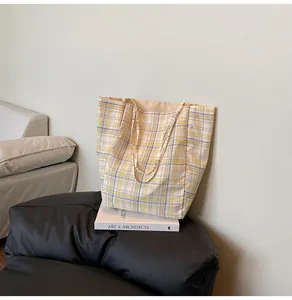 Détail d'un grand sac cabas à carreaux en nylon avec des poignées renforcées