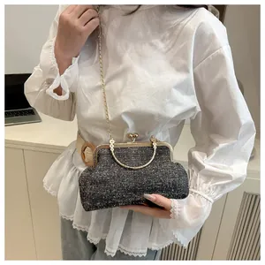 Detail of grey tweed chain bag with gold metal handle and vintage clasp closure