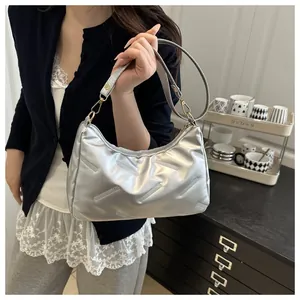 Dettaglio della borsa hobo argento con strisce a rilievo e finiture dorate
