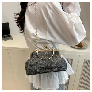 Retro grey polka dot shell bag with gold chain strap shown on a model in a lifestyle setting