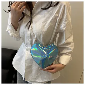 Close-up of heart-shaped crossbody bag with iridescent laser finish and gold chain strap