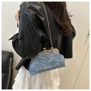 Detail of blue sequin clutch bag with gold chain strap on a stylish model