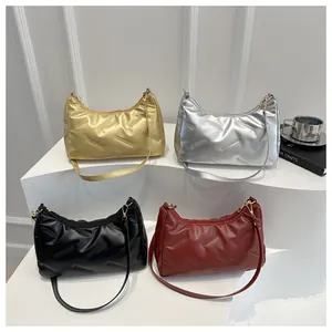 Borse hobo trapuntate in oro argento nero e bordeaux esposte in un ambiente minimal