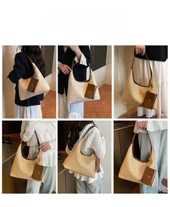 Detail view of large straw tote bag with brown leather straps and detachable coin purse