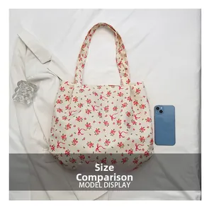 Detailed size comparison of the floral canvas tote bag with a smartphone for scale