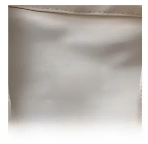 Vue détaillée du patch en silicone mode et des coutures fines sur le sac en toile