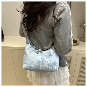 Detail of light blue lace pillow bag with 3D butterflies worn by a model