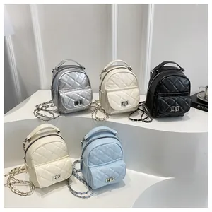 Mini sacs à dos matelassés en cinq couleurs sur marches blanches avec chaînes