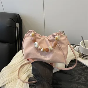 Bolso nube rosa de cuero con asa de perlas grandes y correa larga ajustable