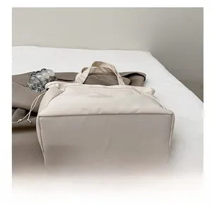 Détail du fond large résistant et du cordon sur ce sac fourre-tout beige en toile