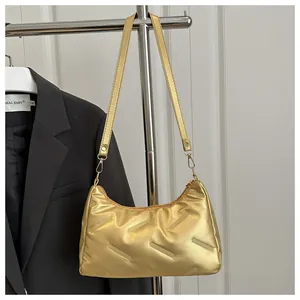 Primo piano della borsa a spalla dorata metallizzata con trama trapuntata e cerniera