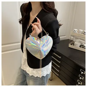 Close-up of heart-shaped crossbody bag with holographic silver laser finish and gold chain