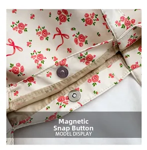 Detailed view of the secure magnetic snap button closure on floral canvas tote bag
