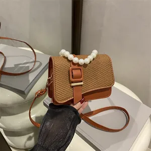 Brown woven crossbody bag with pearl handle and metal buckle in French vintage style