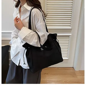 Grand sac cabas noir en toile avec cordon de serrage porté à l'épaule pour femme