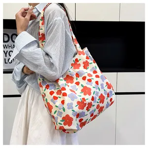 Close-up of floral canvas tote bag with rose print worn over the shoulder by a model