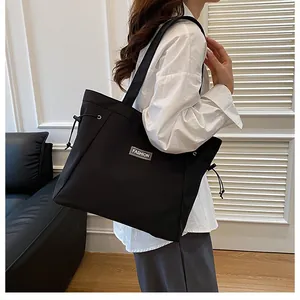 Détail du sac cabas en toile noire avec écusson FASHION et cordons décoratifs