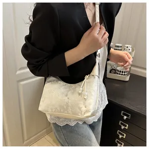 Detailed view of white jacquard hobo bag with floral texture and pearl drawstring charm