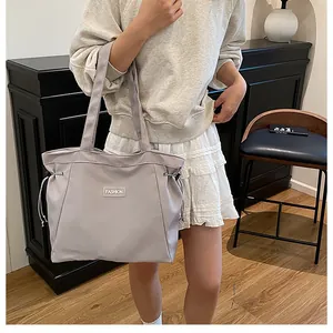 Gros plan du sac cabas en nylon gris clair avec cordon de serrage et patch fashion