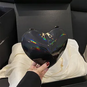 Iridescent black heart-shaped crossbody bag with gold chain and glossy finish