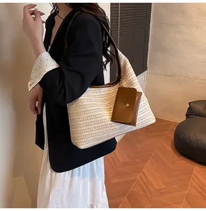 Detail of woven straw tote bag featuring brown leather coin purse and adjustable strap
