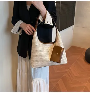 Detail of straw shoulder bag featuring brown leather trim and a small matching pouch