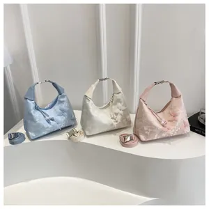 Detailed view of the lace butterfly handbag set in light blue, white, and pink finishes