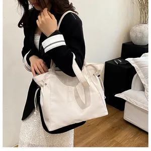 Gros plan d'un grand sac cabas en toile beige avec cordons et bandoulière réglable