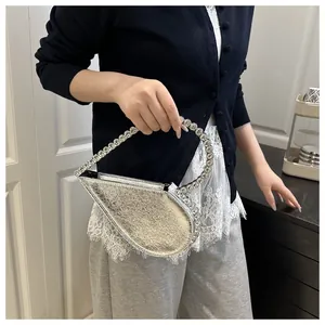 Detail der silbernen asymmetrischen Herztasche mit strassbesetztem Griff für Partys
